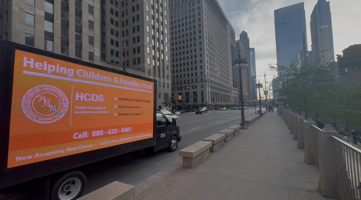 AOTC mobile LED truck showing the HCDS creative on a downtown Chicago street near the Loop