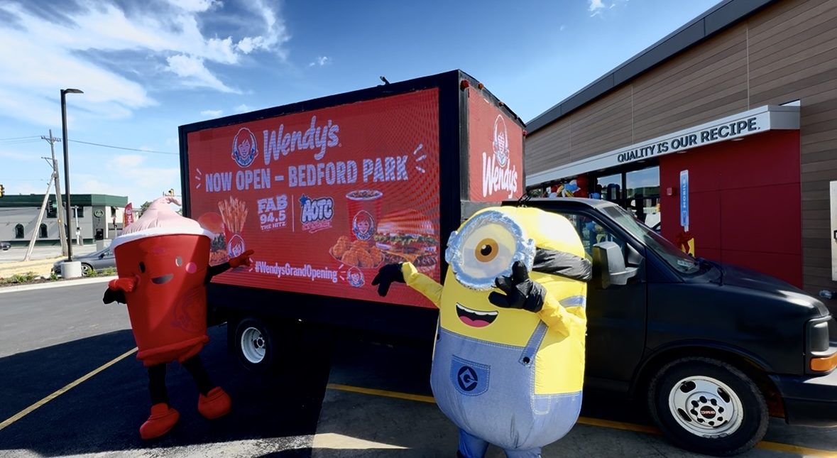 Mascots posing beside the AOTC LED truck at the Wendy's grand opening